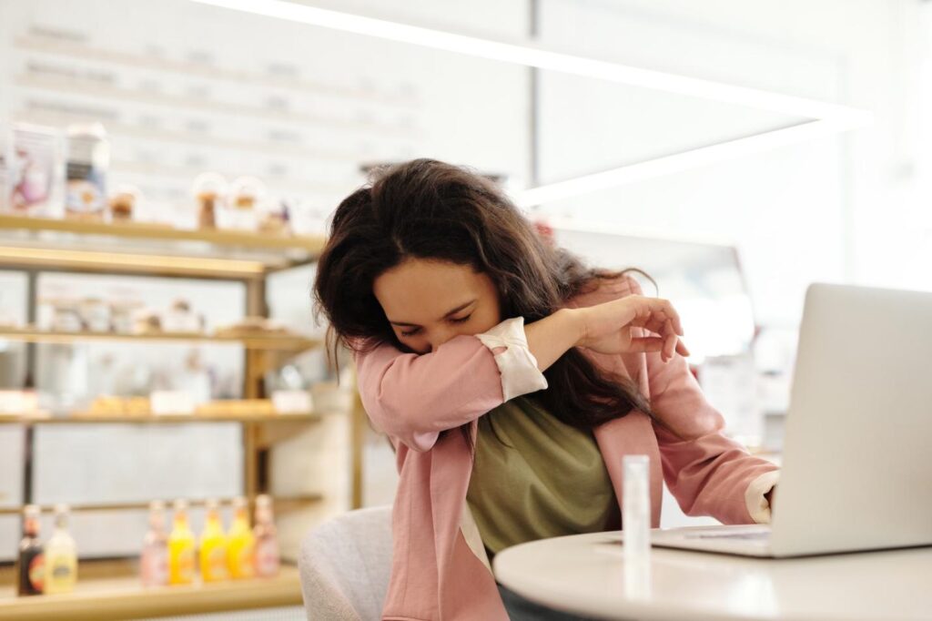 A Sick Woman in a Pink Blazer Coughing